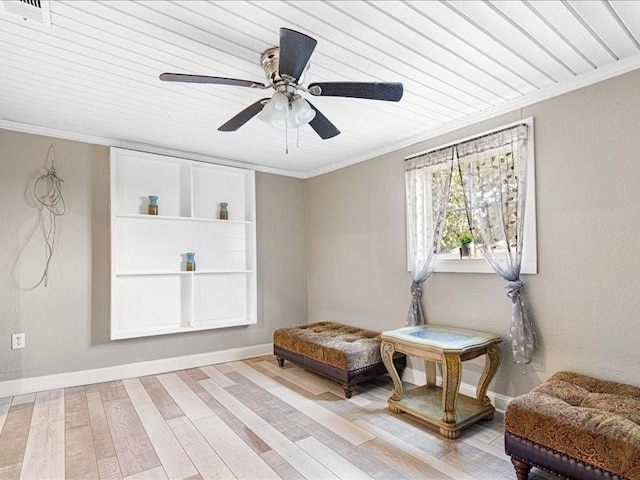 living area with light hardwood / wood-style flooring, ornamental molding, and ceiling fan