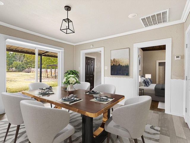 dining area featuring ornamental molding and wood-type flooring