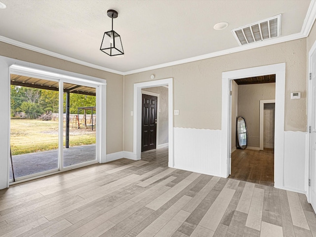 unfurnished dining area featuring ornamental molding and light wood-type flooring