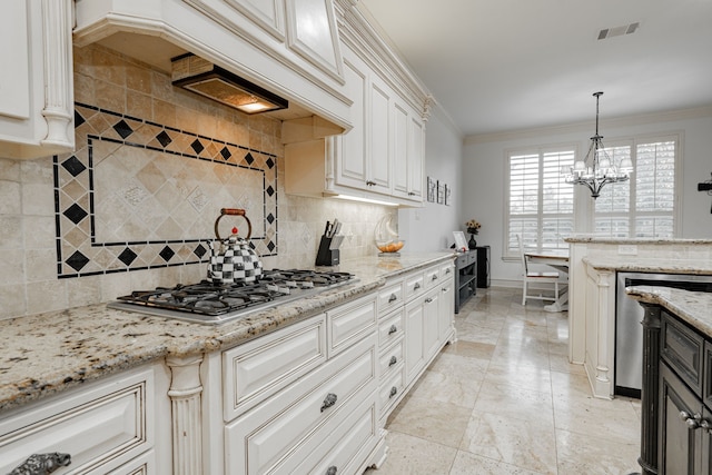 kitchen with tasteful backsplash, pendant lighting, crown molding, and stainless steel gas stovetop