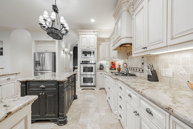 kitchen with light stone countertops, stainless steel appliances, and hanging light fixtures