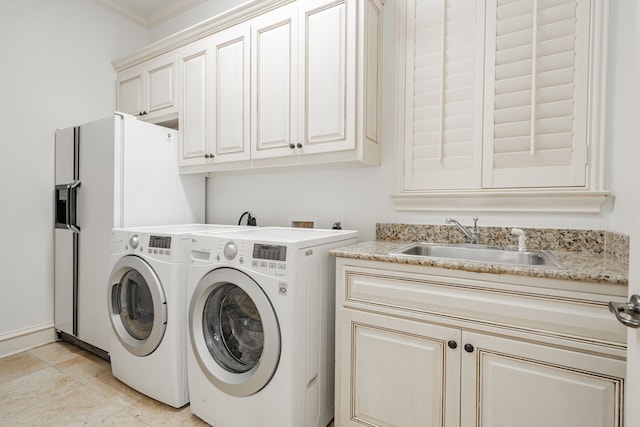 clothes washing area with washer and dryer, crown molding, cabinets, and sink