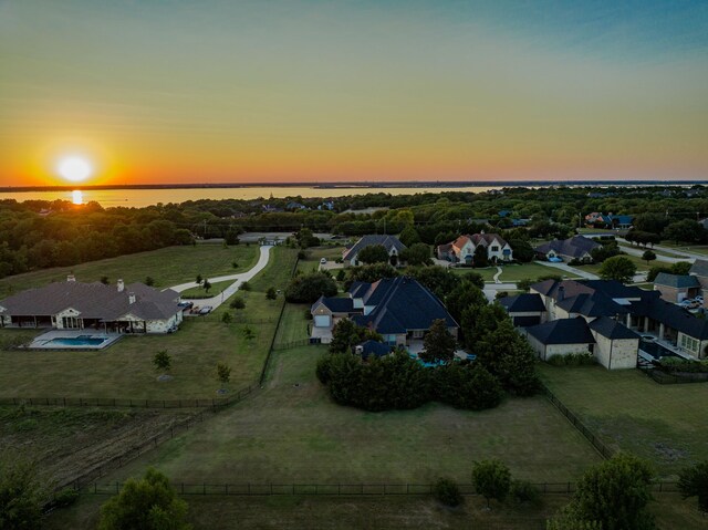 aerial view at dusk featuring a water view