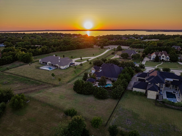 aerial view at dusk featuring a water view