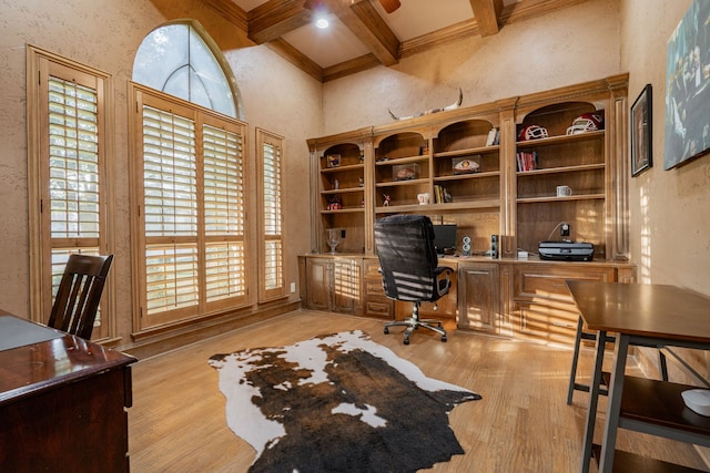 home office with coffered ceiling, ornamental molding, light hardwood / wood-style floors, and beam ceiling