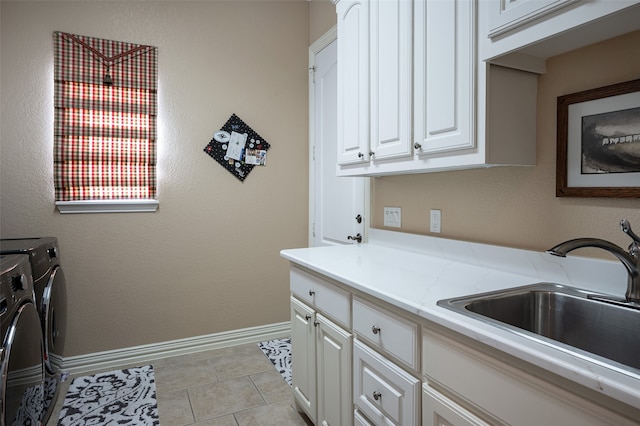 clothes washing area with separate washer and dryer, cabinets, sink, and light tile patterned flooring