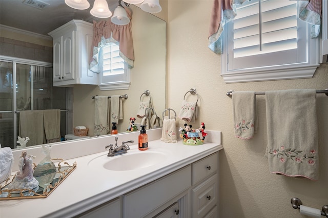 bathroom with walk in shower, crown molding, and vanity