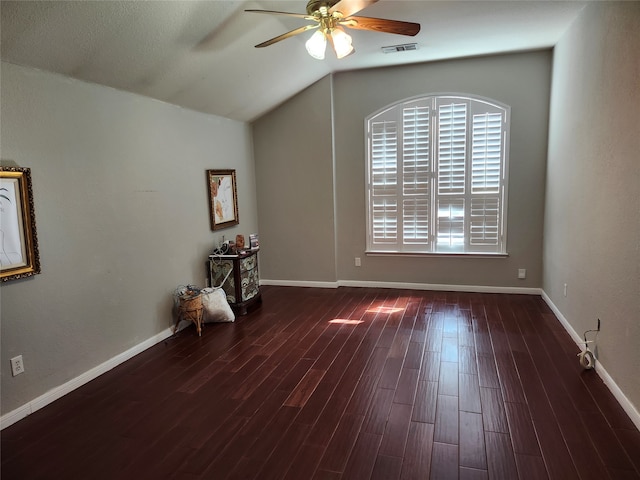 empty room with lofted ceiling, dark hardwood / wood-style floors, and ceiling fan