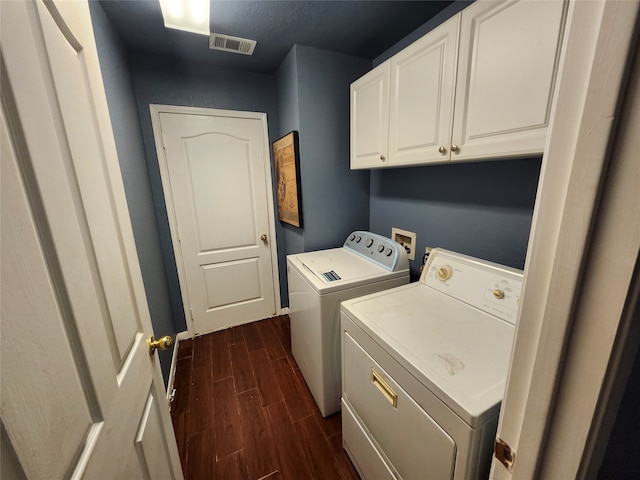 clothes washing area featuring cabinets and washing machine and dryer