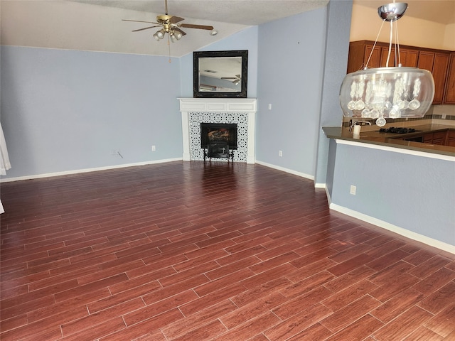 unfurnished living room with lofted ceiling, wood-type flooring, and ceiling fan