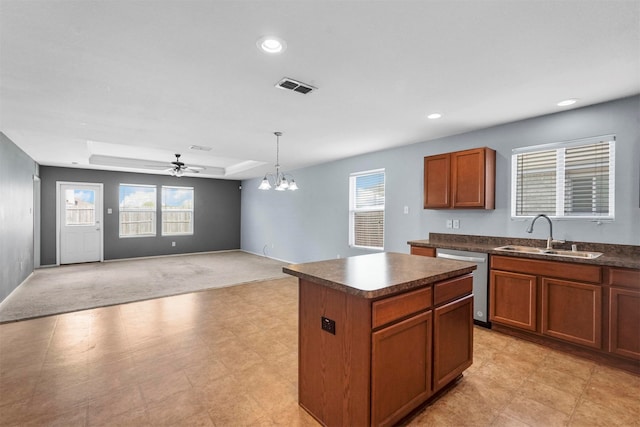 kitchen with dishwasher, sink, ceiling fan with notable chandelier, a kitchen island, and light carpet