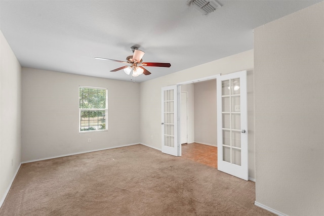 unfurnished room with ceiling fan, light colored carpet, and french doors