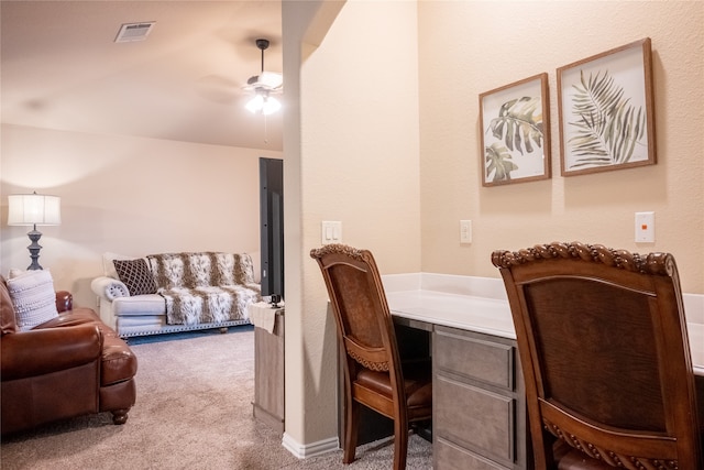 carpeted office space with ceiling fan