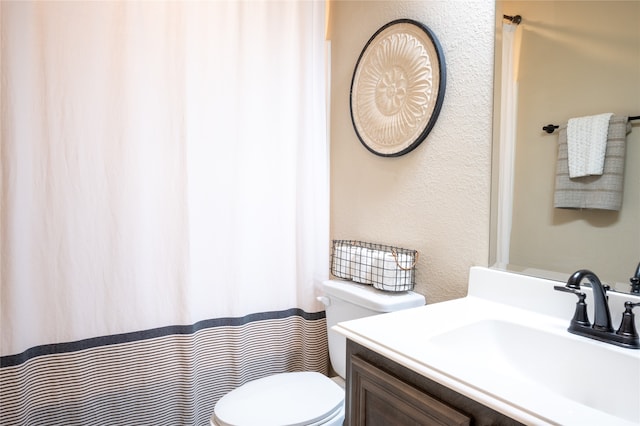 bathroom with walk in shower, vanity, and toilet