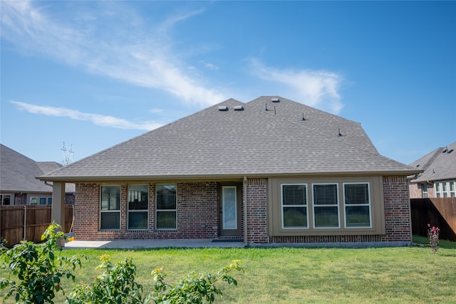 rear view of house featuring a patio area and a yard