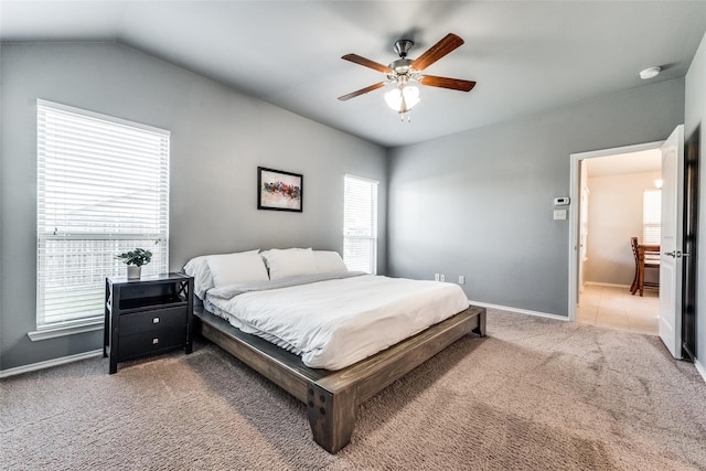 carpeted bedroom with multiple windows, ceiling fan, and vaulted ceiling