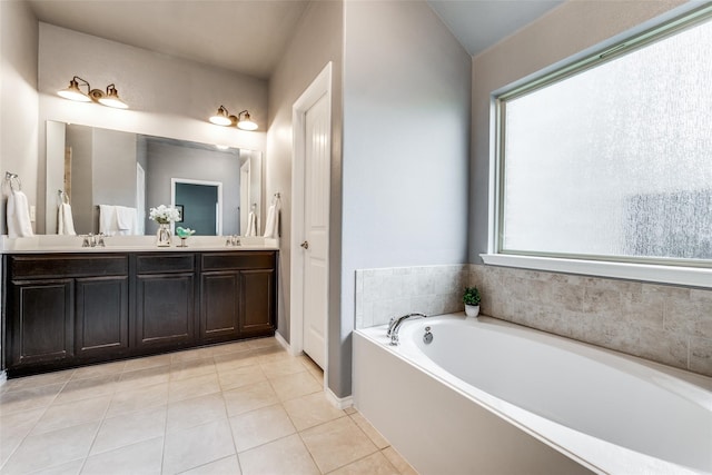 bathroom featuring tile patterned flooring, a healthy amount of sunlight, a bathing tub, and vanity