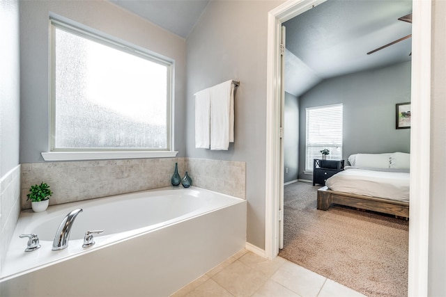 bathroom with lofted ceiling, ceiling fan, tile patterned flooring, and a washtub