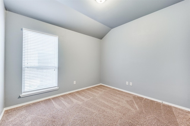 carpeted spare room featuring lofted ceiling