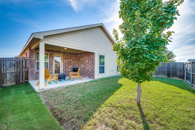 back of house with a yard and a patio