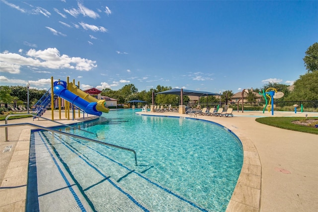 view of swimming pool with a water slide and a playground