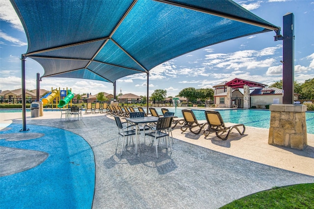 view of pool with a playground and a patio