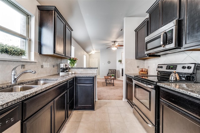 kitchen with stainless steel appliances, sink, ceiling fan, decorative backsplash, and lofted ceiling