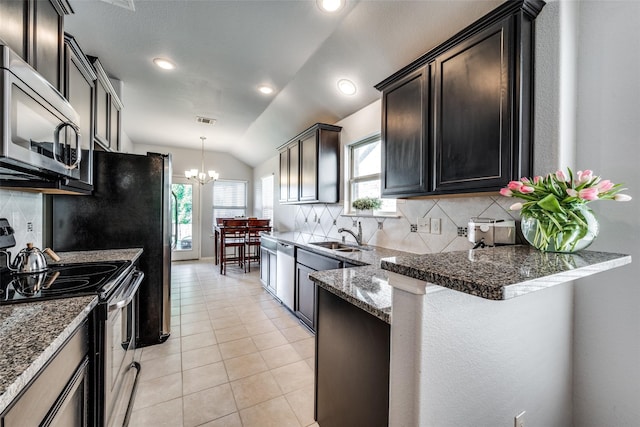 kitchen with stainless steel appliances, a notable chandelier, sink, lofted ceiling, and decorative backsplash