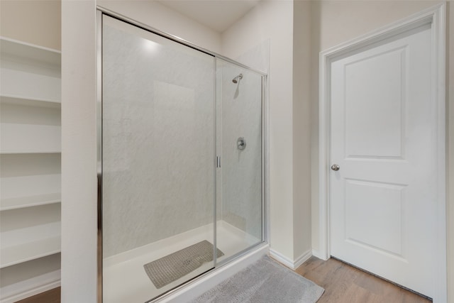 bathroom with a shower with door and hardwood / wood-style flooring