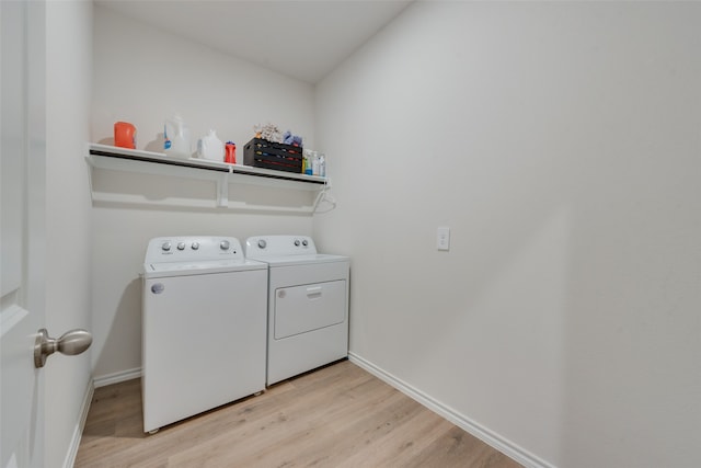 washroom with light hardwood / wood-style floors and washer and dryer