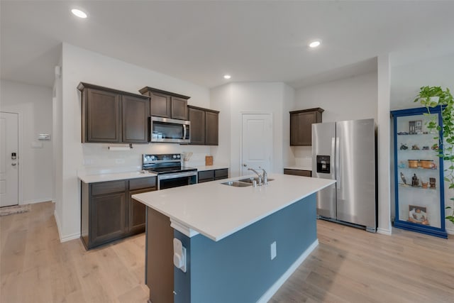 kitchen featuring light wood-type flooring, appliances with stainless steel finishes, dark brown cabinets, and sink