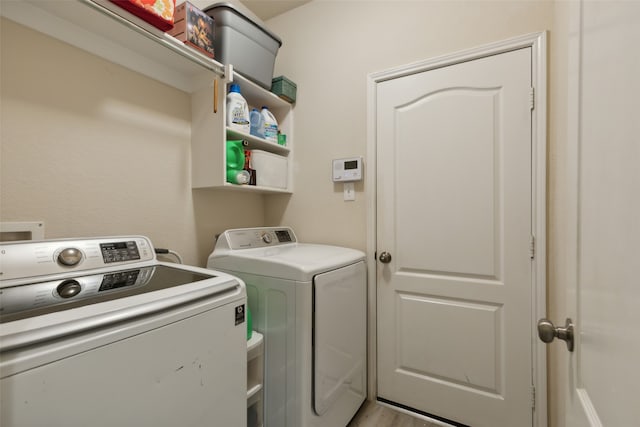 laundry area featuring light wood-type flooring and washer and clothes dryer