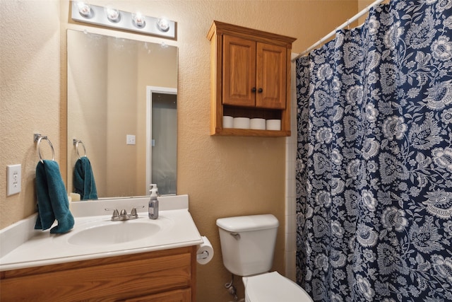 bathroom with a shower with curtain, vanity, and toilet