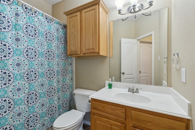 bathroom with vanity, a notable chandelier, and toilet