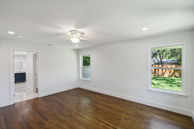 spare room with dark hardwood / wood-style flooring and ceiling fan