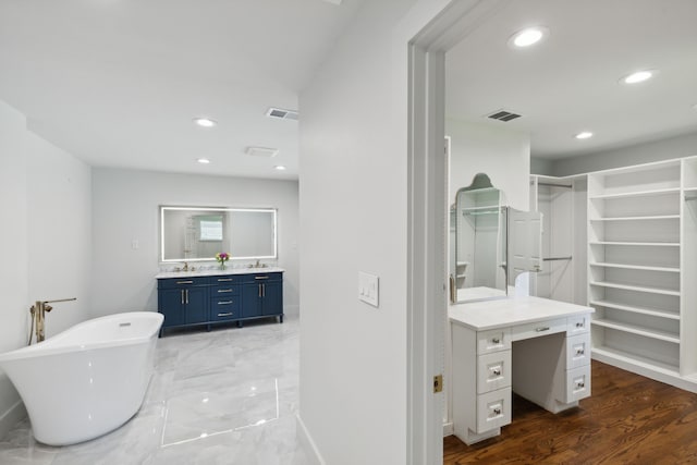 bathroom with vanity, hardwood / wood-style floors, and a bathtub