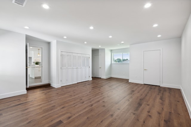 unfurnished living room with dark wood-type flooring