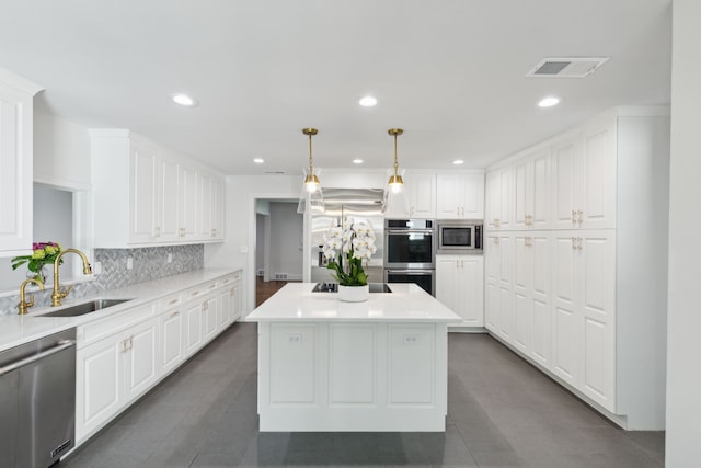 kitchen featuring a center island, white cabinetry, sink, built in appliances, and pendant lighting