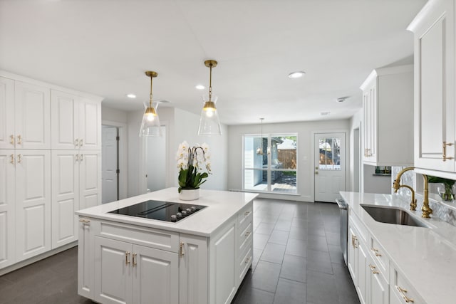 kitchen featuring decorative light fixtures, black electric stovetop, white cabinetry, and sink