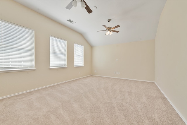 spare room with light colored carpet, lofted ceiling, and ceiling fan