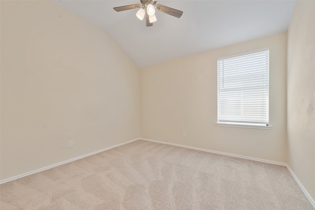 spare room featuring vaulted ceiling, ceiling fan, and light colored carpet