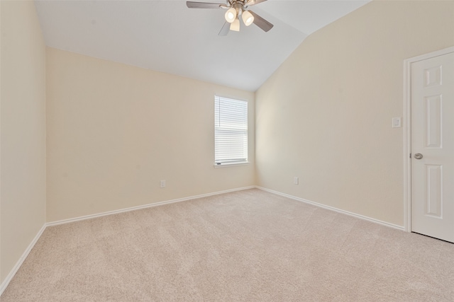 spare room featuring vaulted ceiling, light carpet, and ceiling fan