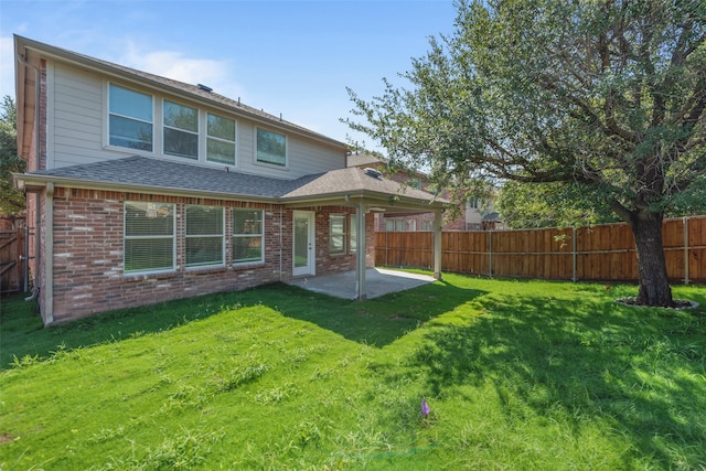 back of house with a patio area and a yard