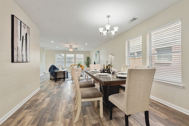 dining room with ceiling fan with notable chandelier and dark hardwood / wood-style flooring