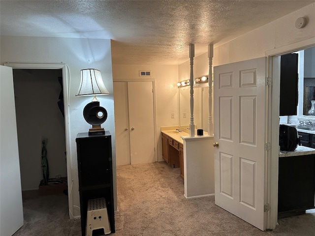 hallway featuring carpet and a textured ceiling