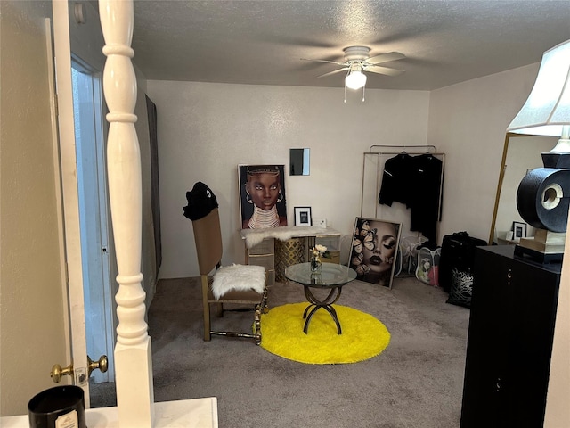 sitting room with carpet, ceiling fan, and a textured ceiling