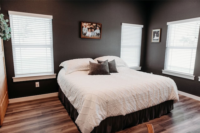 bedroom with dark hardwood / wood-style floors