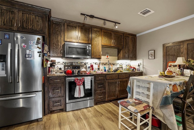 kitchen with backsplash, light wood-type flooring, ornamental molding, appliances with stainless steel finishes, and dark brown cabinets