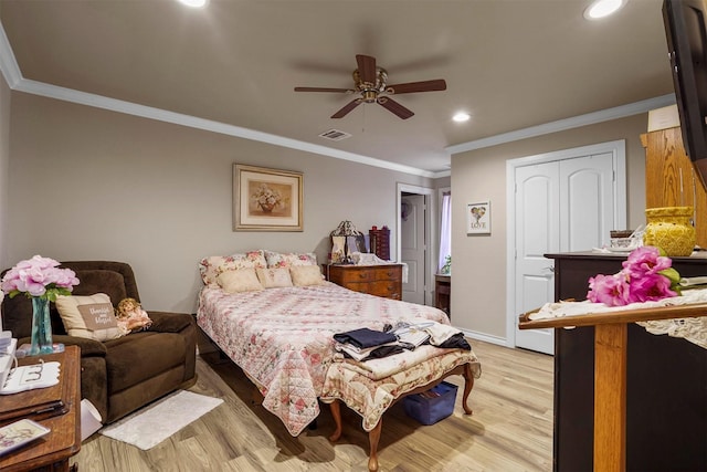 bedroom featuring a closet, light hardwood / wood-style flooring, ceiling fan, and ornamental molding