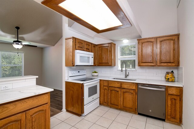 kitchen featuring a healthy amount of sunlight, white appliances, sink, and ceiling fan